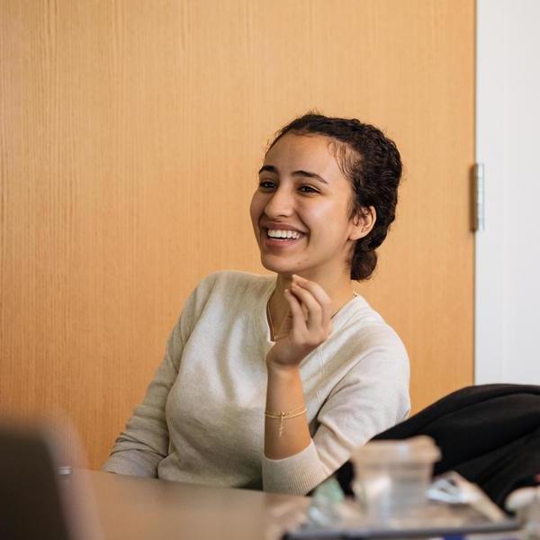 An Agnes Scott religious and social justice major smiles while sitting in class.